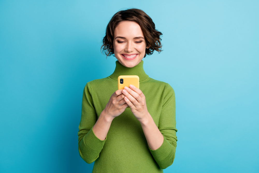 Portrait,Of,Positive,Cheerful,Blogger,Girl,Use,Cellphone,Read,Social